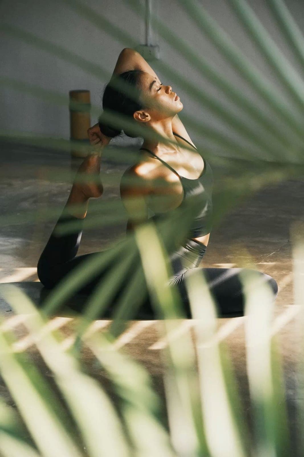A woman stretching among palm leaves